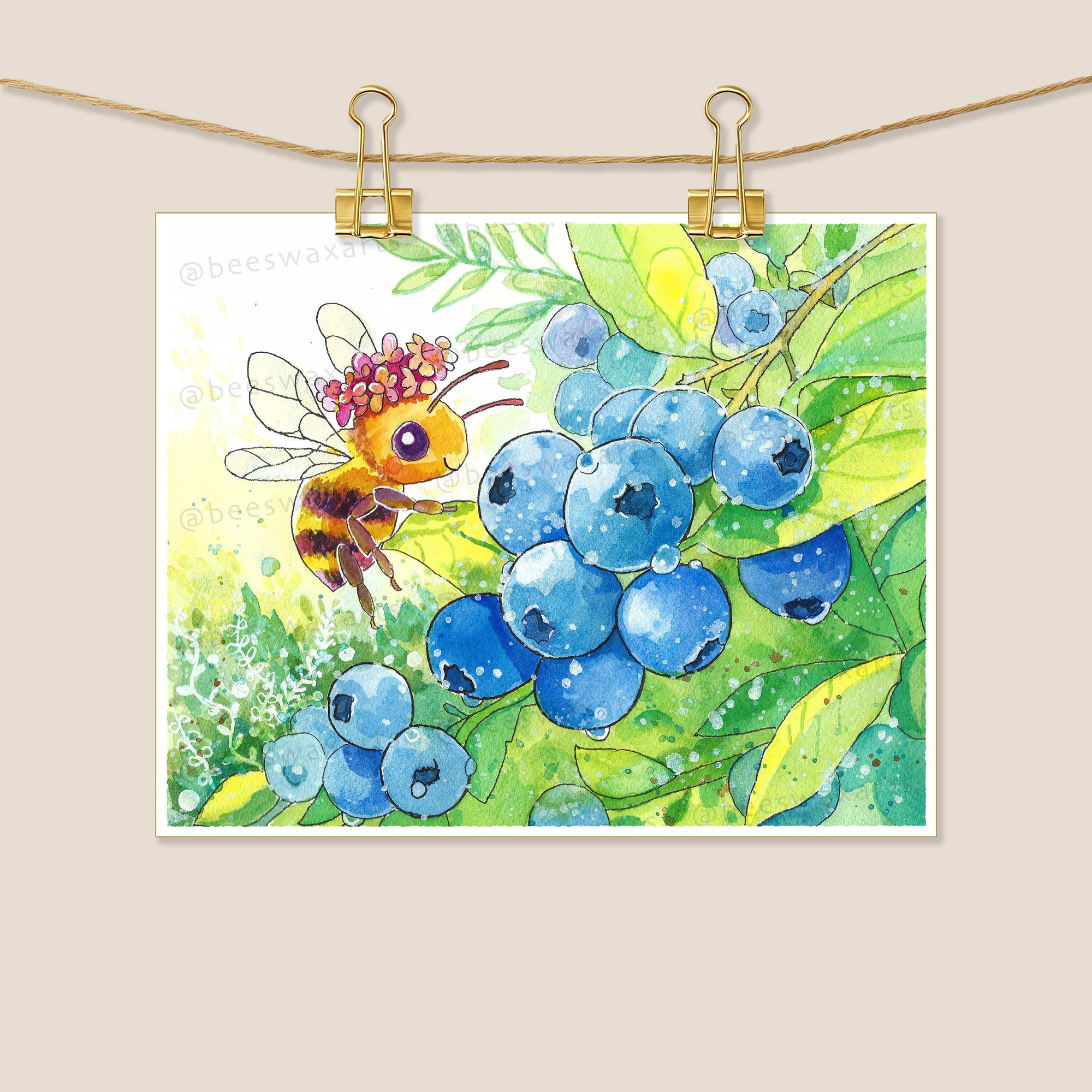 A bee wearing a flower crown hovers near a cluster of ripe blueberries on a leafy green branch.