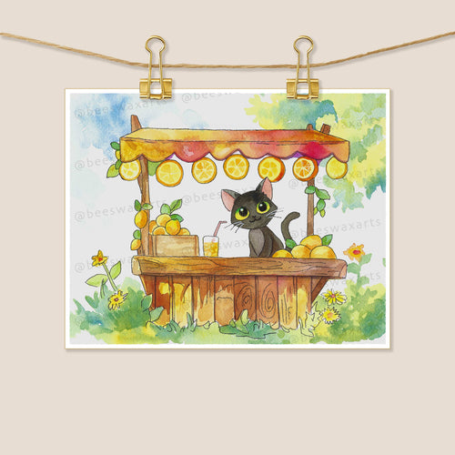 Black Cat Lemonade Stand by Beeswax Arts Watercolors is a watercolor print of a black cat at a wooden lemonade stand with lemons and greenery, making it a unique collector’s piece.