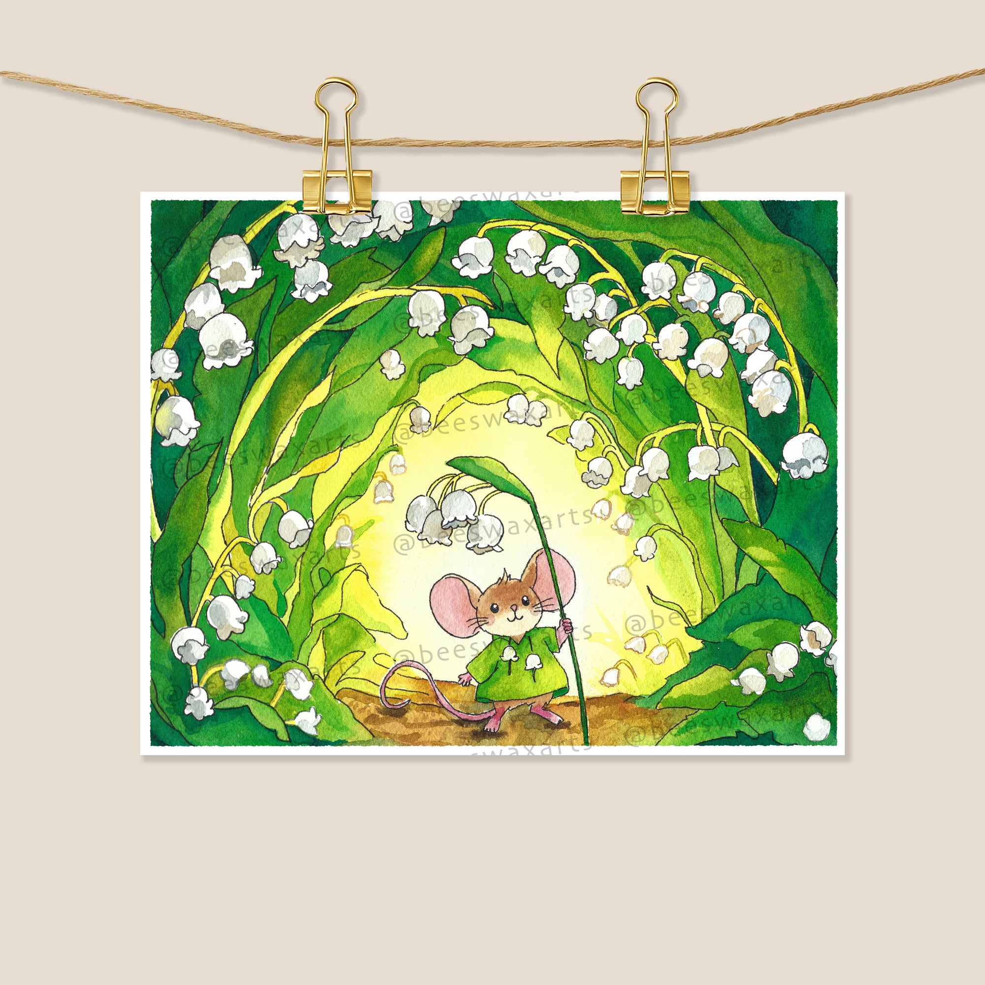 May Mouse by Beeswax Arts Watercolors is an 8x10 archival print featuring a mouse in green under lily of the valley arches, sunlight streaming through leaves. Clipped to a string with two gold clips for display.
